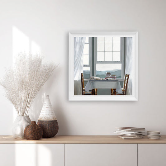 Framed print of a restful cat lying on a table with books.