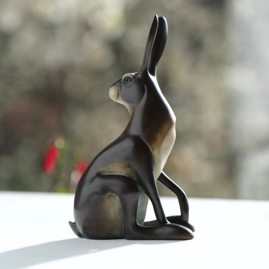 Bronze sculpture of a hare on a blurred natural background