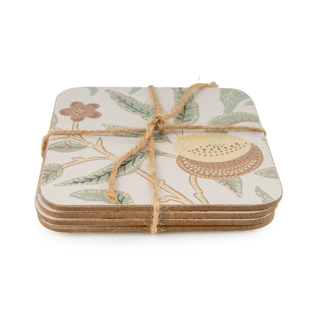 Set of four square coasters with floral and fruit design tied with twine on a white background