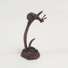 A miniature bronze sculpture of a snail on grass by David Meredith.