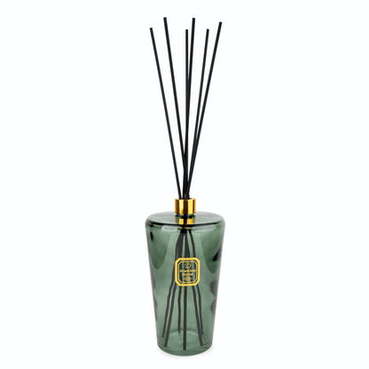 Green diffuser bottle with black sticks on a white background