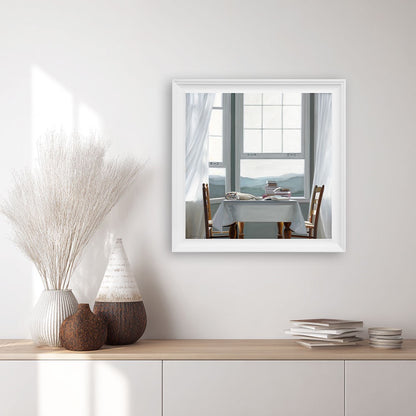 Framed print of a restful cat lying on a table with books.