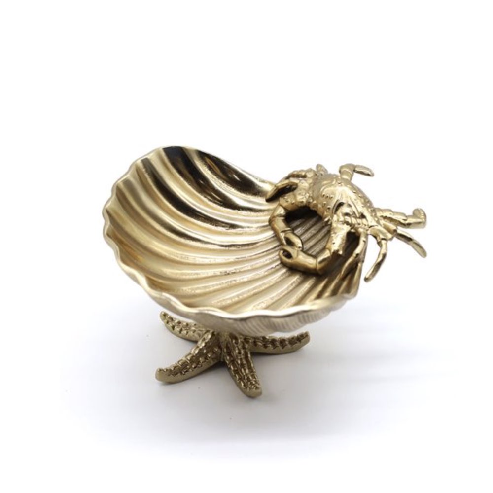 Gold shell-shaped jewellery bowl with a starfish and crab on a white background