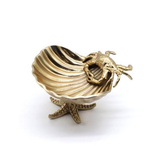 Gold shell-shaped jewellery bowl with a starfish and crab on a white background