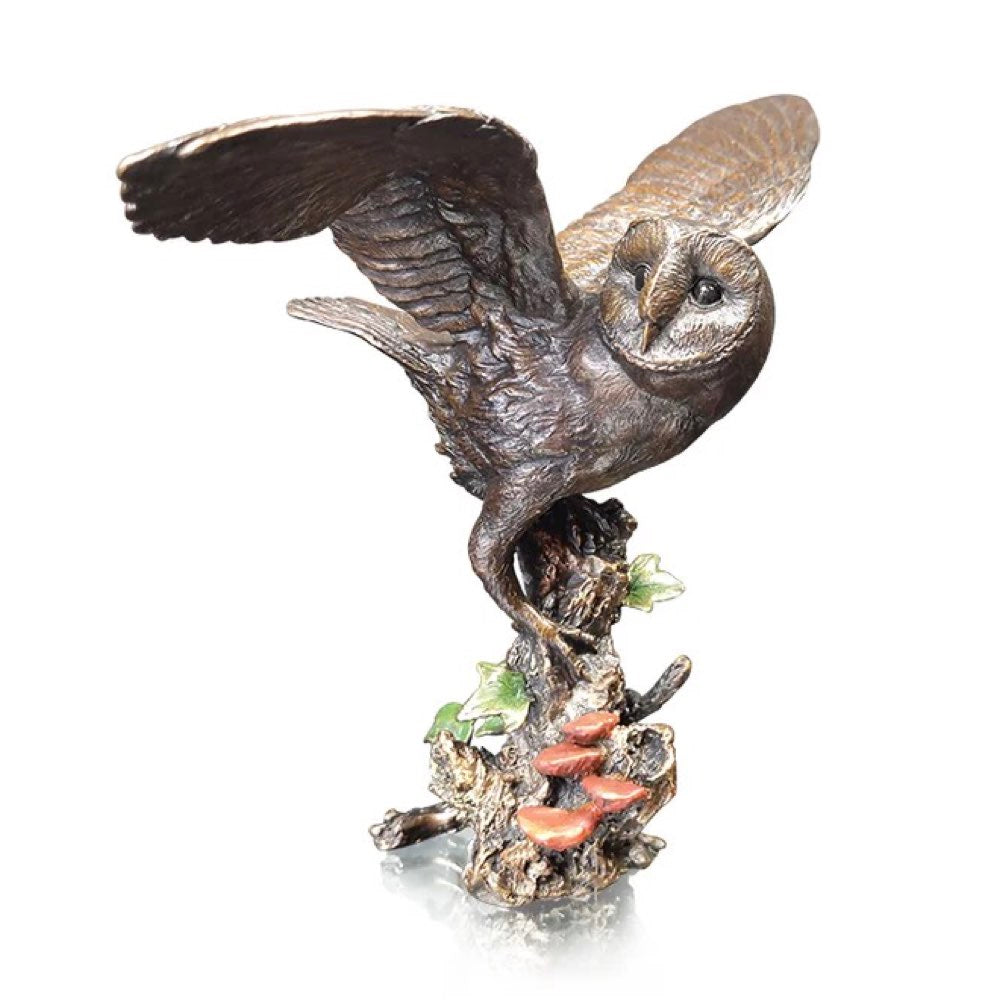 Bronze sculpture of an owl perched on a branch with a white background