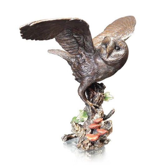 Bronze sculpture of an owl perched on a branch with a white background