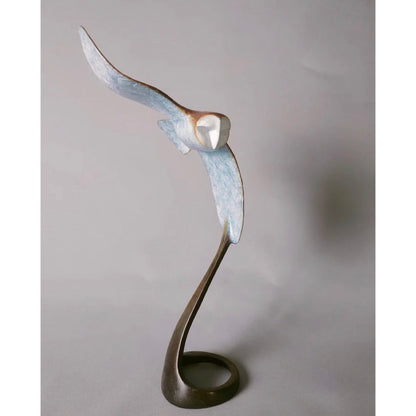 Abstract sculpture of a bird in flight on a plain background