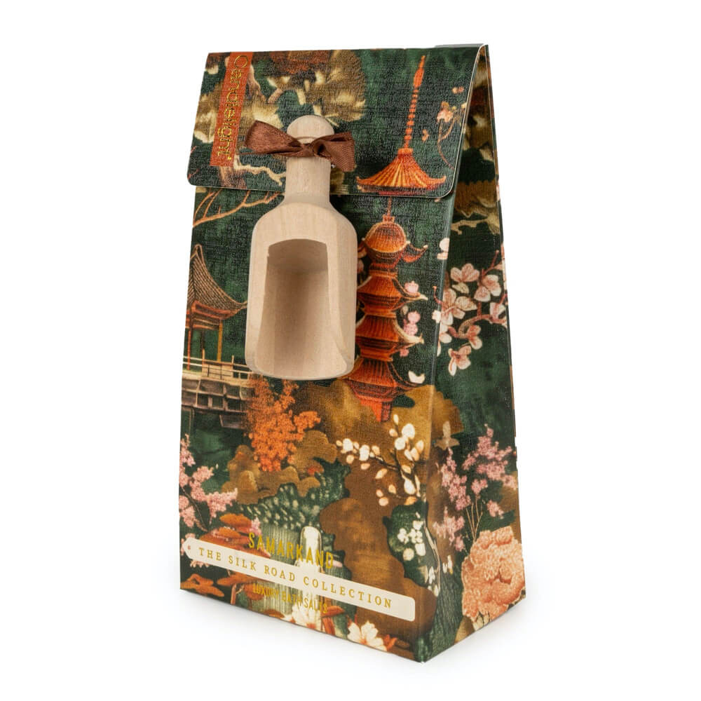 Decorative packaging with a traditional design featuring pagodas and floral elements, containing a small beige scoop.