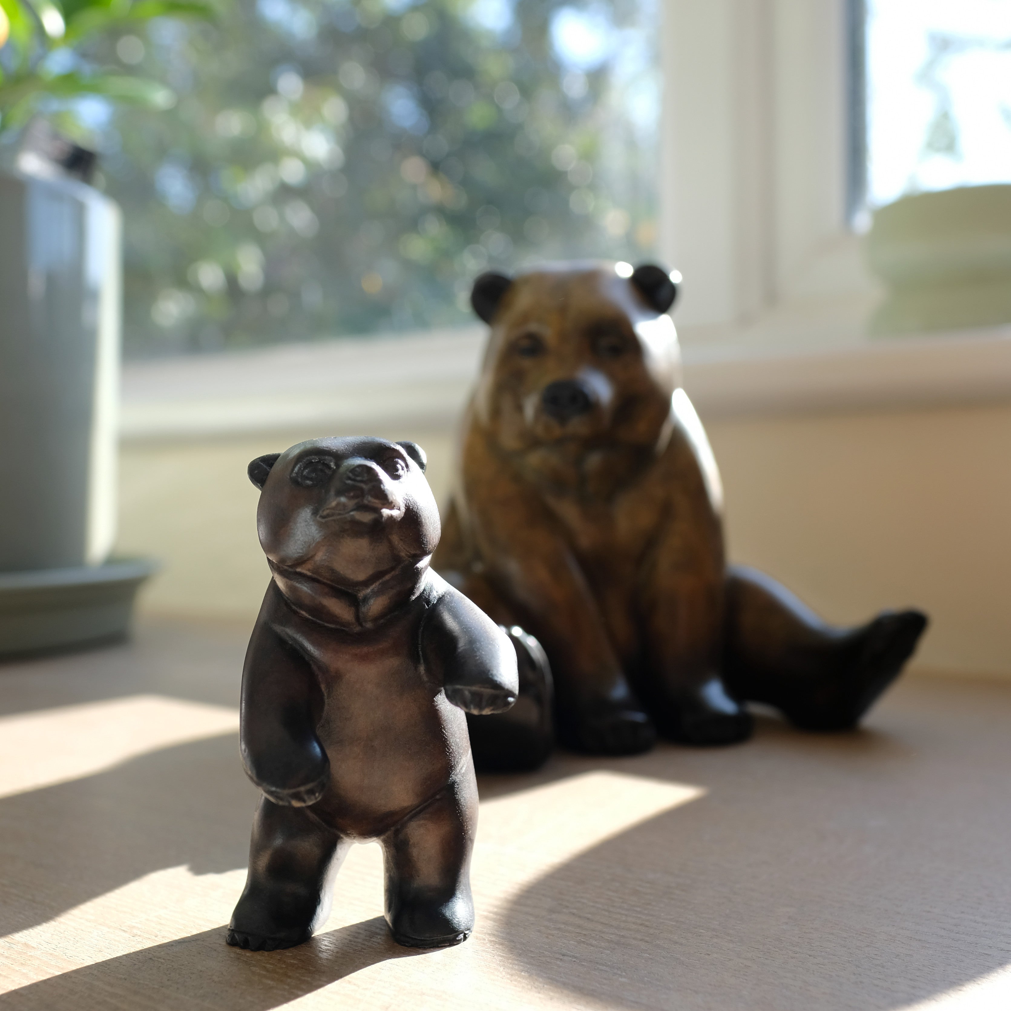 Two bear figurines on a surface with a blurred background