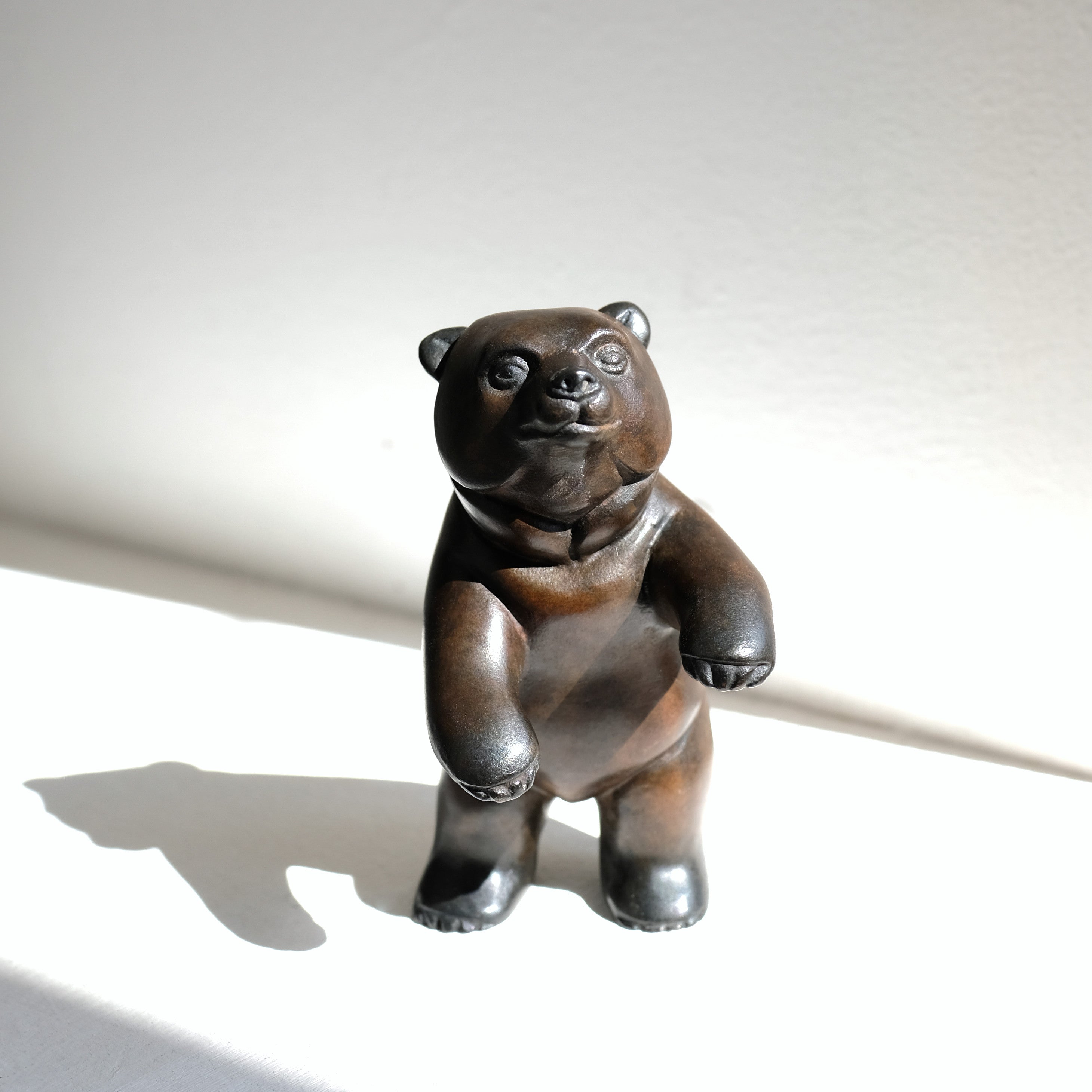 Bronze bear figurine on a white background
