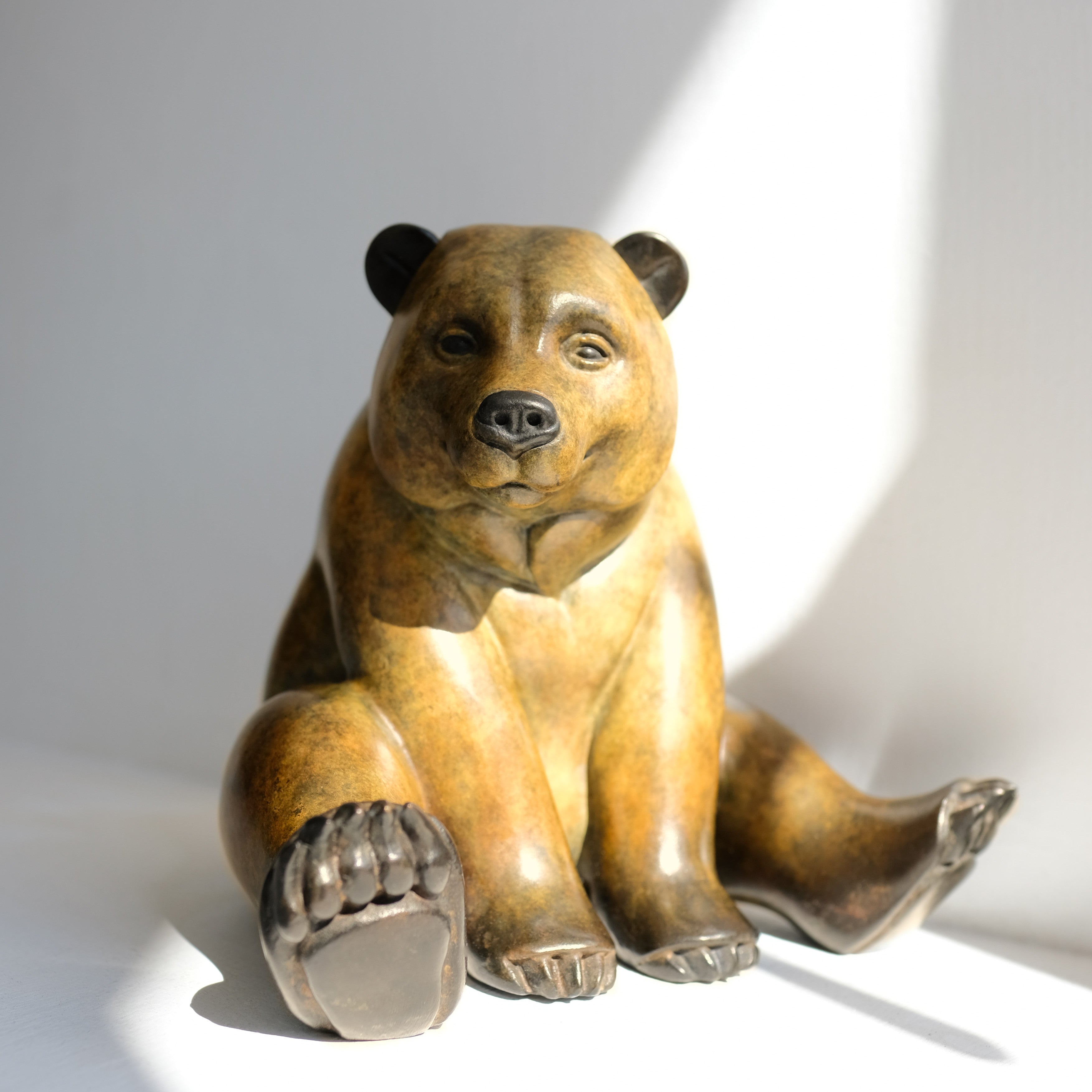 Bronze bear sculpture on a white background
