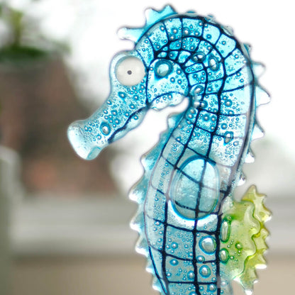 Decorative glass seahorse with bubble design on a blurred background