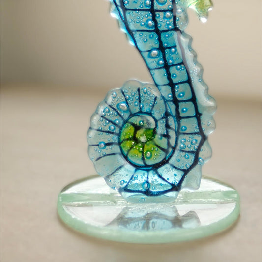 Decorative seahorse figurine with blue and green design on a beige background