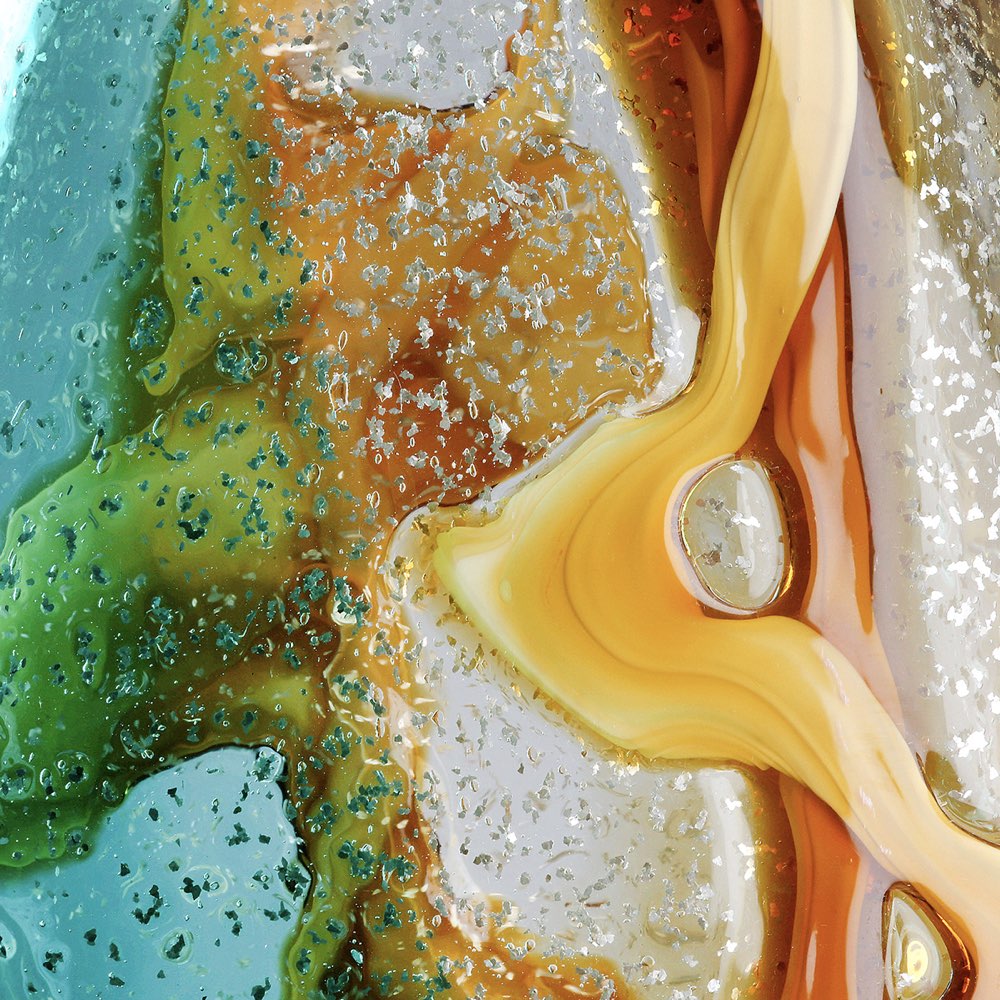 Close-up of a colorful, textured surface with orange, green, and blue hues.