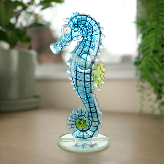 Decorative blue seahorse figure on a table with a blurred indoor background