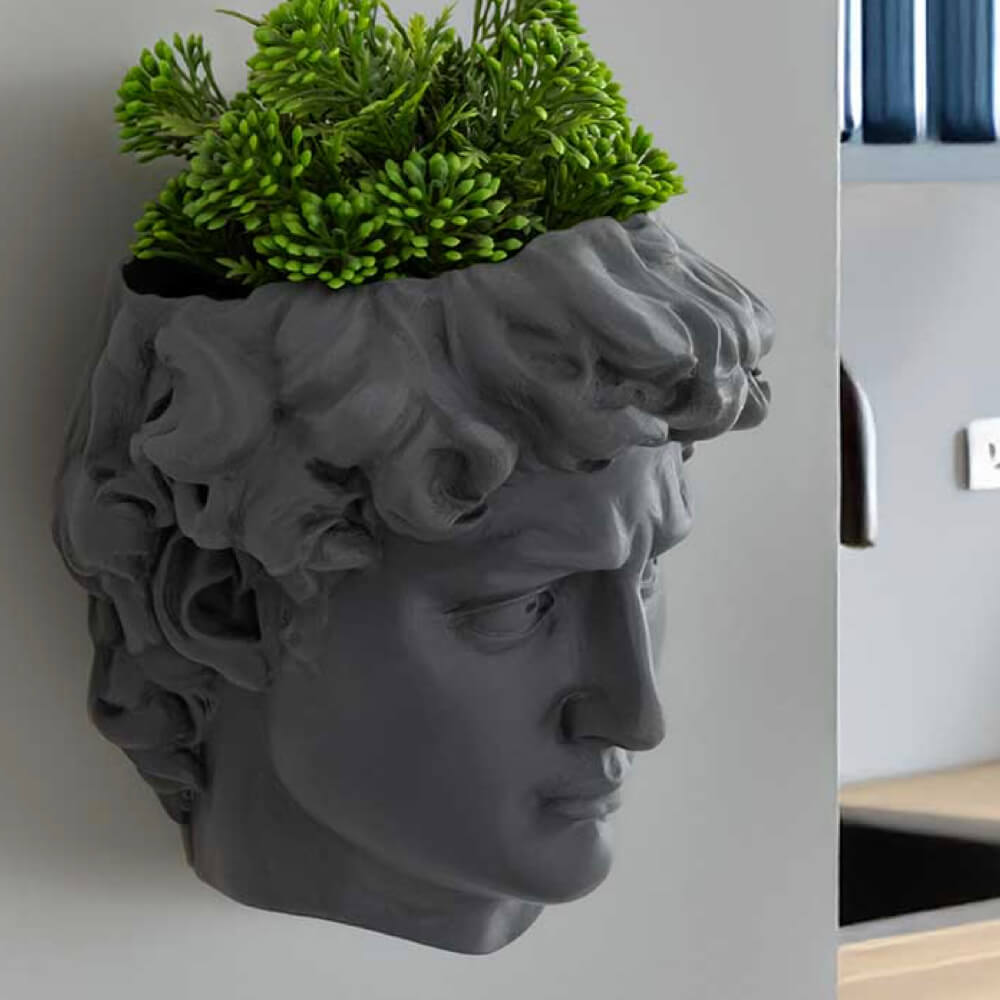David wall planter in cool grey with trailing plants, sculptural stone-effect wall-mounted planter for herbs and succulents