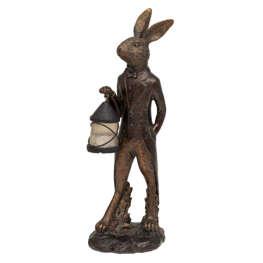 Statue of a rabbit in a suit holding a lantern on a white background