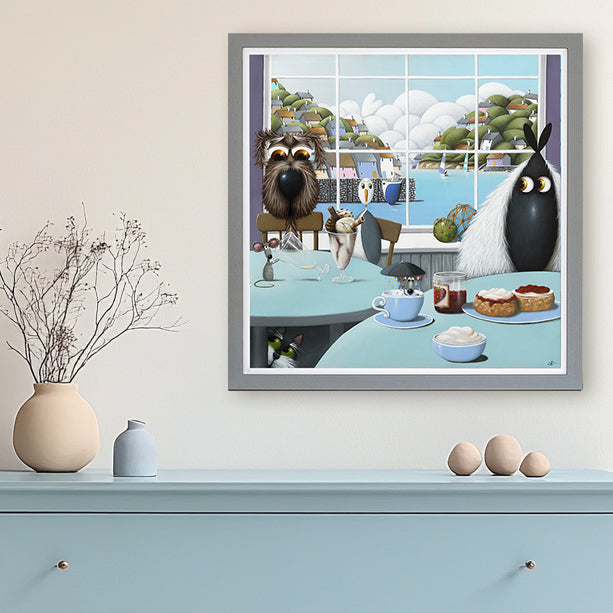 Framed artwork of a dog, seagull  and sheep at a table with a scenic view outside
