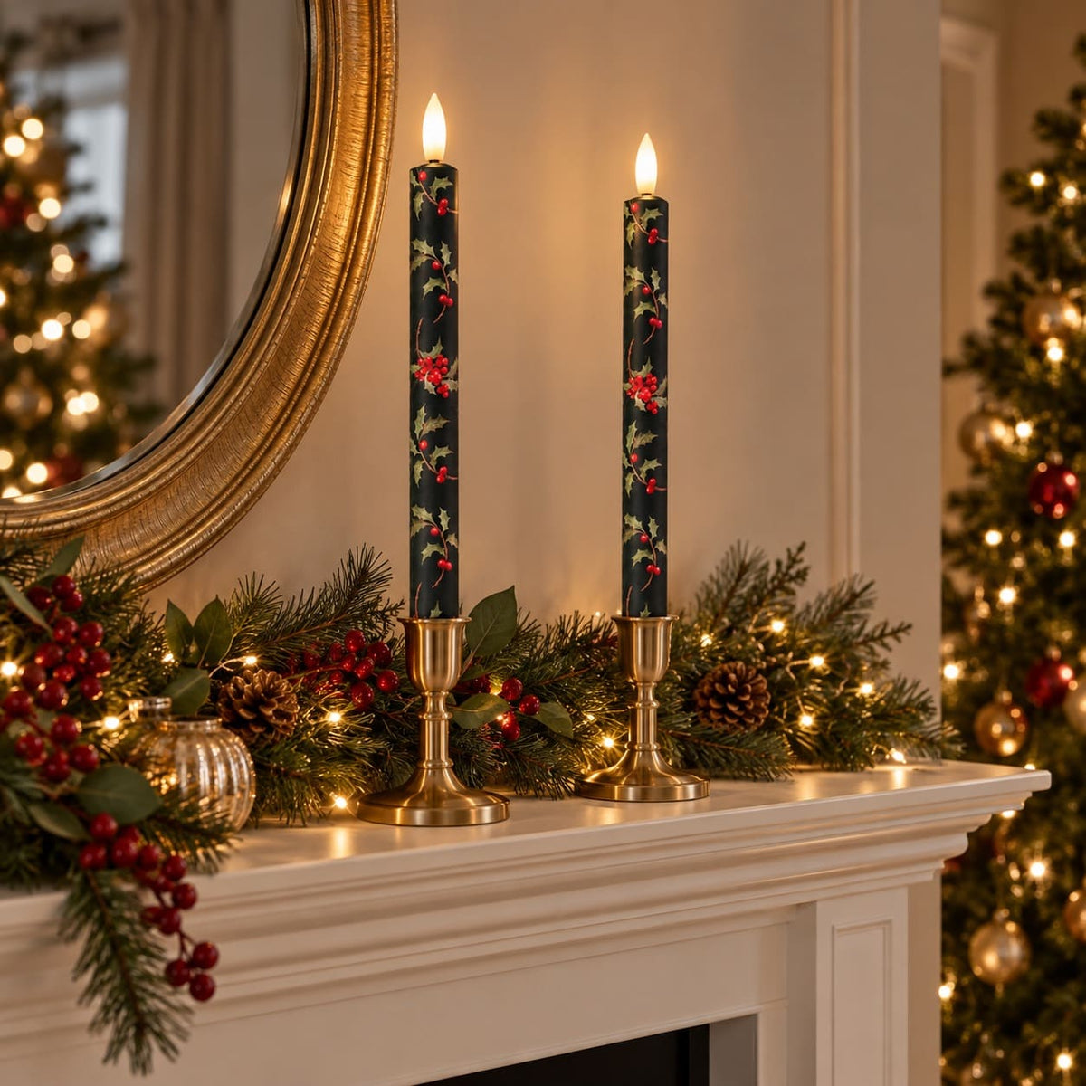 Two tall dark green Christmas candles with a red and green holly pattern, displayed in gold candlesticks on a white fireplace mantel decorated with pine branches, pinecones, and warm white lights.