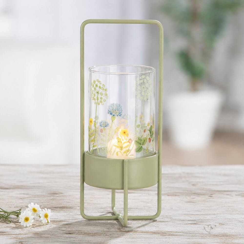 Green lantern with floral design on a wooden surface