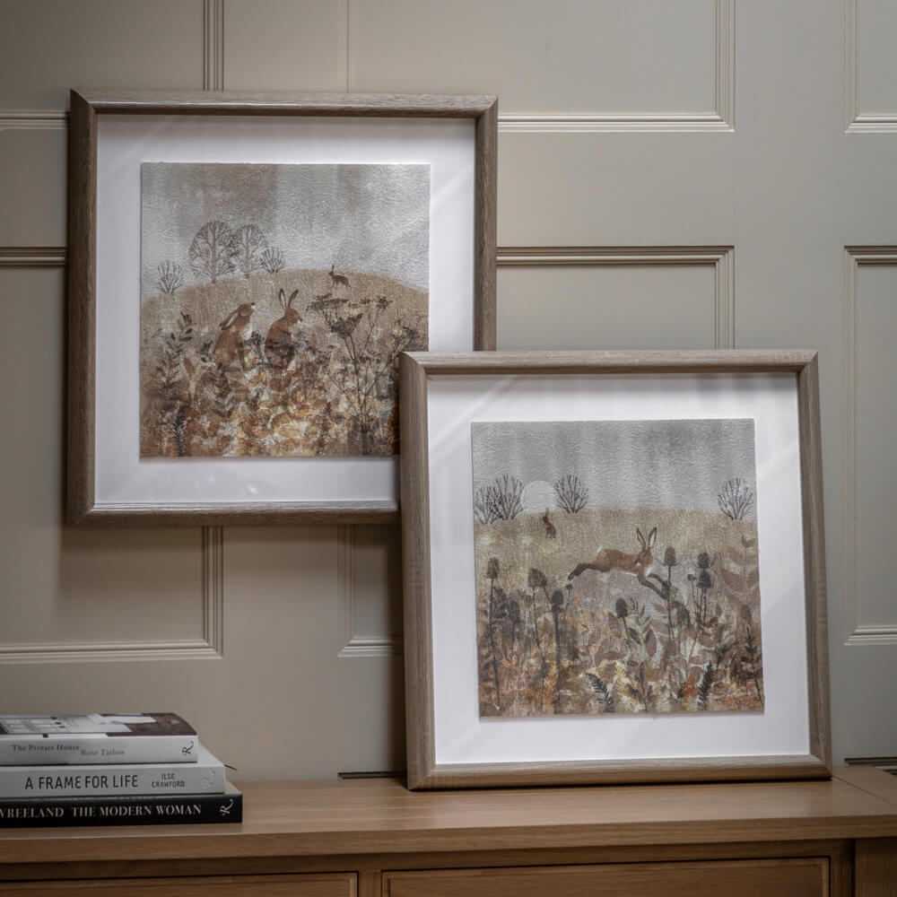 Meadow Mischief wall art with hares in the countryside, framed in weathered oak for rustic interiors