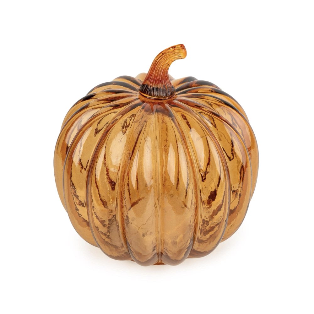 An amber glass pumpkin with a ribbed texture and a curved stem, isolated on a white background.