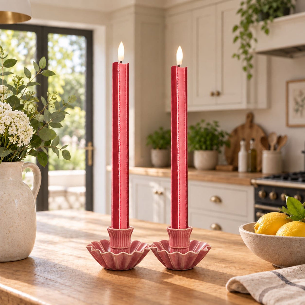 Two Red and Pink striped fabric wrapped LED candles stand front and centre in an aesthetic kitchen scene.