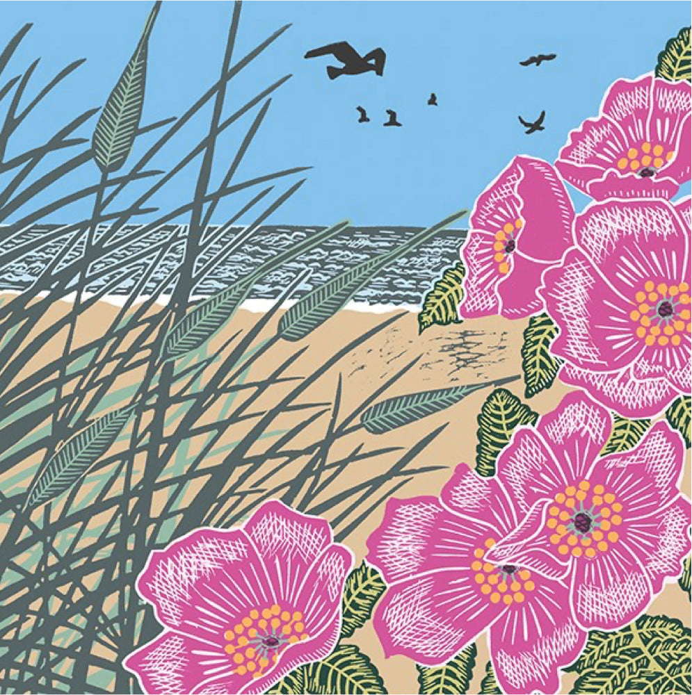 A stylised coastal scene print featuring large pink flowers in the foreground, beach grass, sandy shore, ocean, blue sky, and small birds.