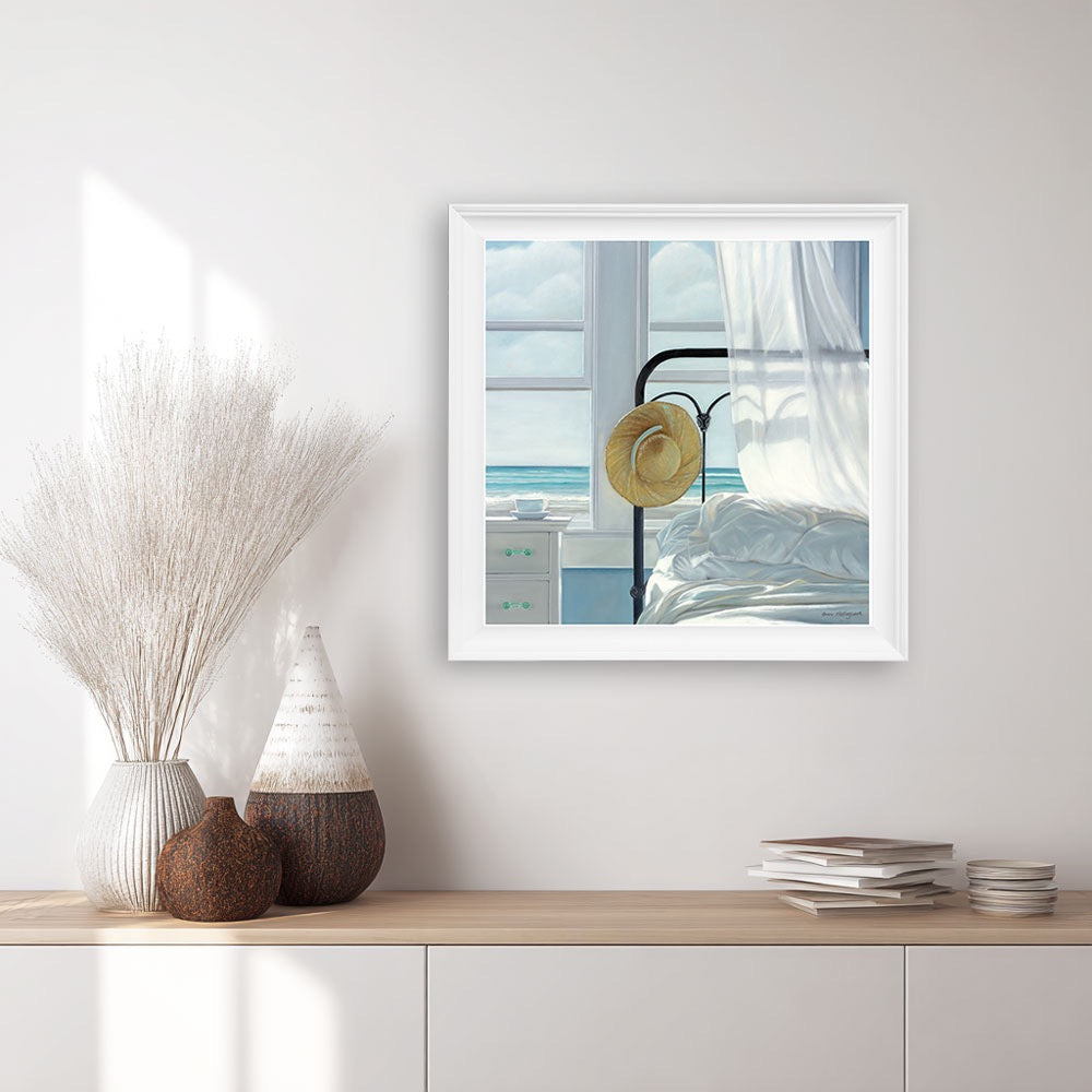 Framed artwork of a bedroom scene with a hat on a bed, displayed on a wall above a wooden shelf with decorative items.