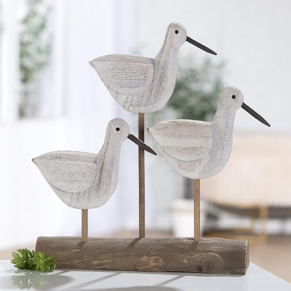 Wooden bird figurines on a stand with a blurred indoor background