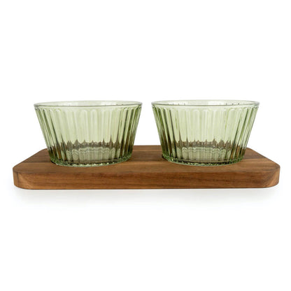 Two green glass bowls on a wooden stand against a white background