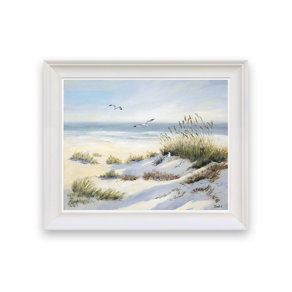 Framed artwork of a beach scene with sand, grass, and birds.