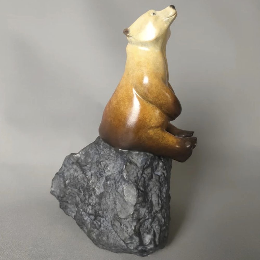 Bear sculpture on a rock against a gray background