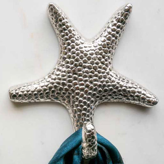 Silver starfish-shaped hook with a blue fabric loop on a light background