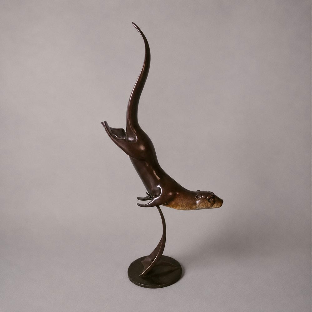 Bronze sculpture of a swimming otter.