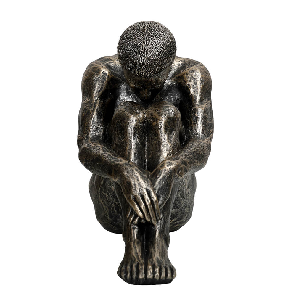 The Contemplating Man Sculpture in dark bronze-effect finish, seated male figure with head bowed and arms around knees