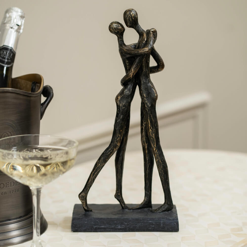 Bronze sculpture of two people embracing.