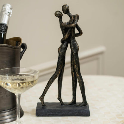 Bronze sculpture of two people embracing.