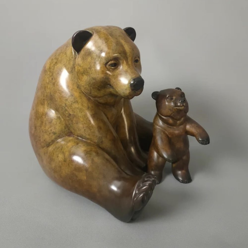 Bronze sculpture of a bear and cub on a gray background