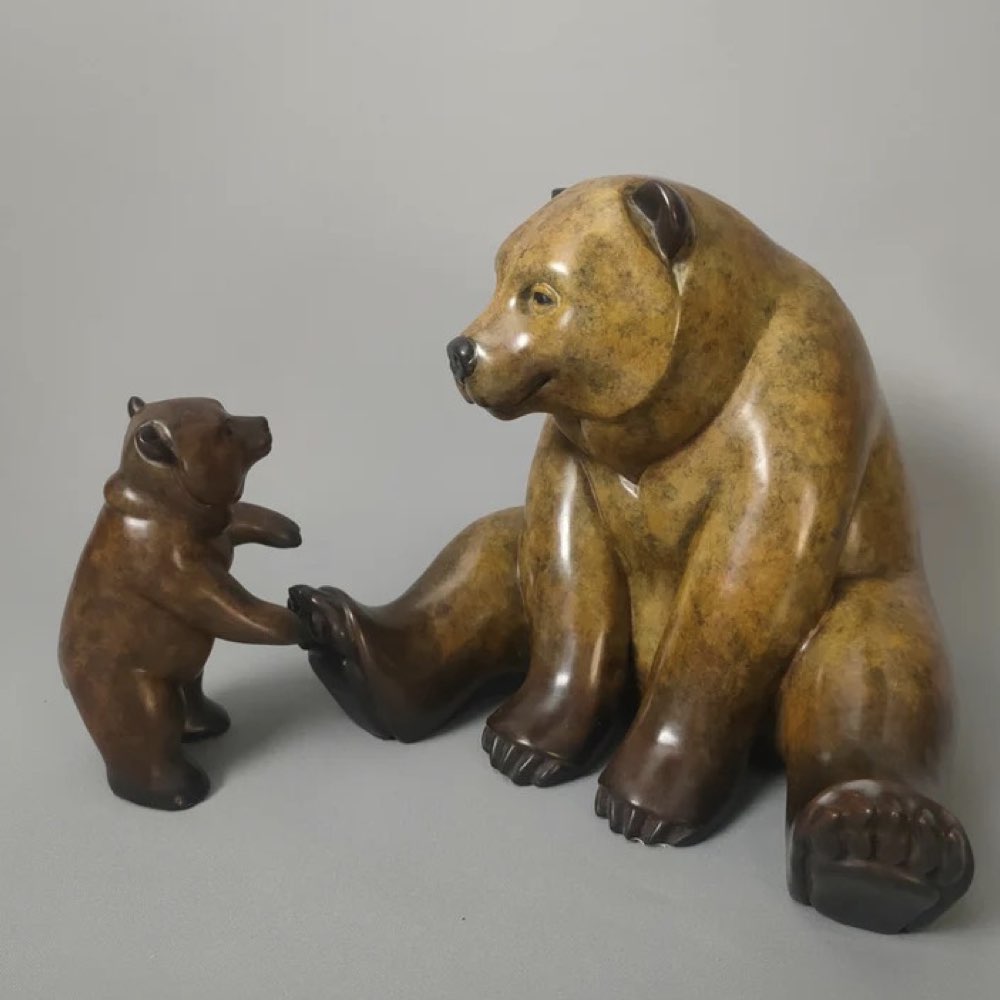 Bronze sculpture of a bear and cub on a gray background