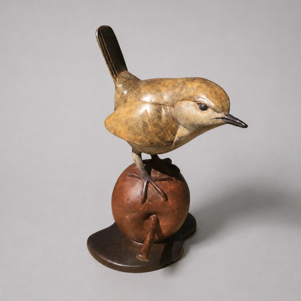 Bronze wren perched on an apple.