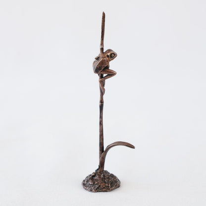 Bonsai bronze frog perched on a grass stem 