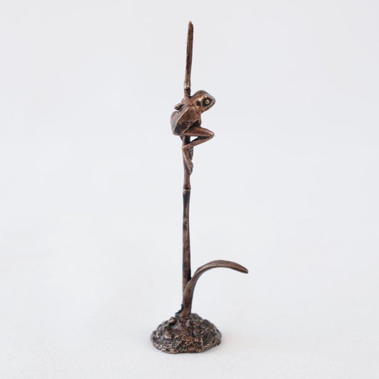 Bonsai bronze frog perched on a grass stem 