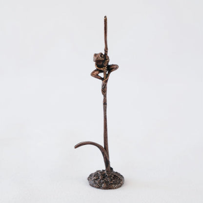 Bonsai bronze frog perched on a grass stem 