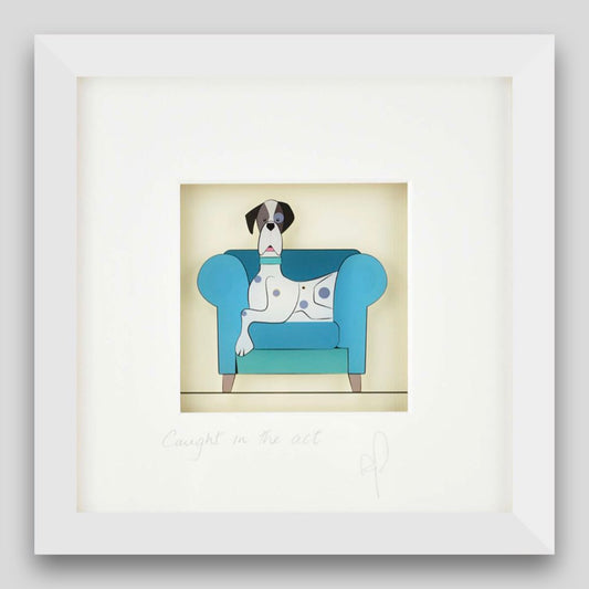 Framed print of a dog caught sitting on the sofa 